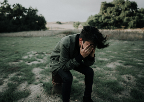 photo of a young man with his head in his hands